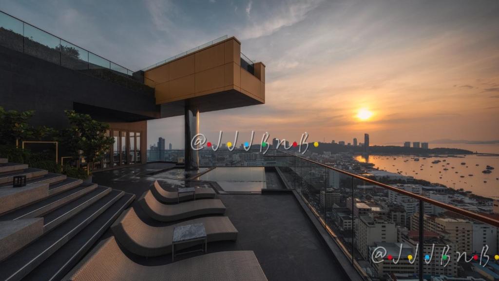 - une vue sur le coucher du soleil depuis un bâtiment avec des bancs dans l'établissement Edge Central Pattaya by JJJ, à Pattaya