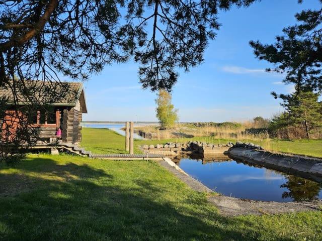 una casa sentada junto a un estanque en un campo en Elimaa-Lepiku, en Hõbesalu
