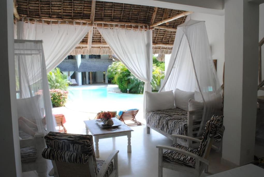 een woonkamer met een bank, stoelen en een tafel bij Swordfish Villas Samaki House (n.4) in Malindi