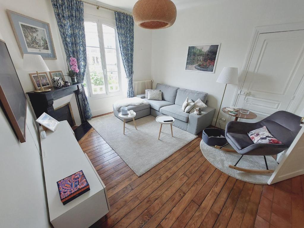 un salon avec un canapé et une chaise dans l'établissement Villa Capucine - Maison de ville avec jardin dans Vernon-Giverny, à Vernon