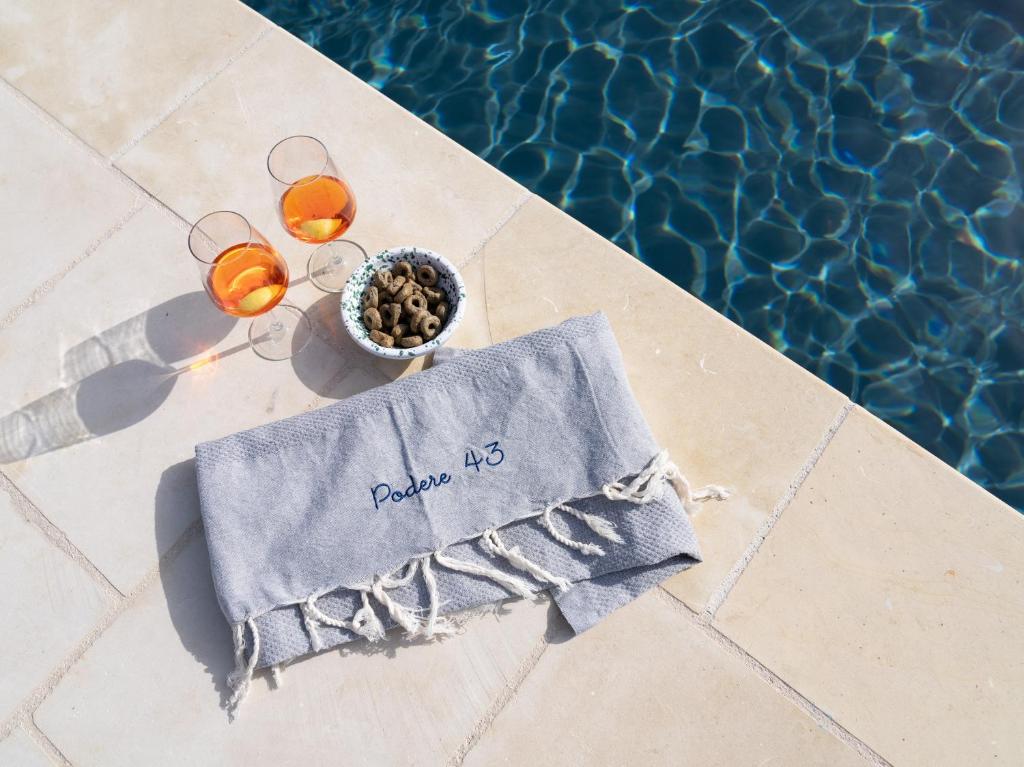 a table with glasses and a napkin next to a pool at Podere 43 Charme B&B in Otranto