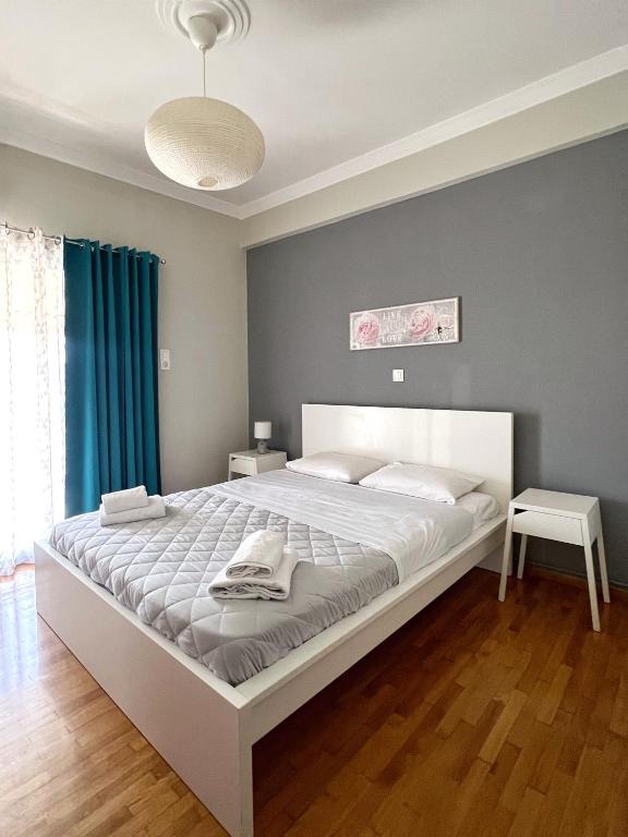 een slaapkamer met een groot bed met een blauwe muur bij Mario's comfortable local apartment, next to metro station, close to Acropolis in Athene