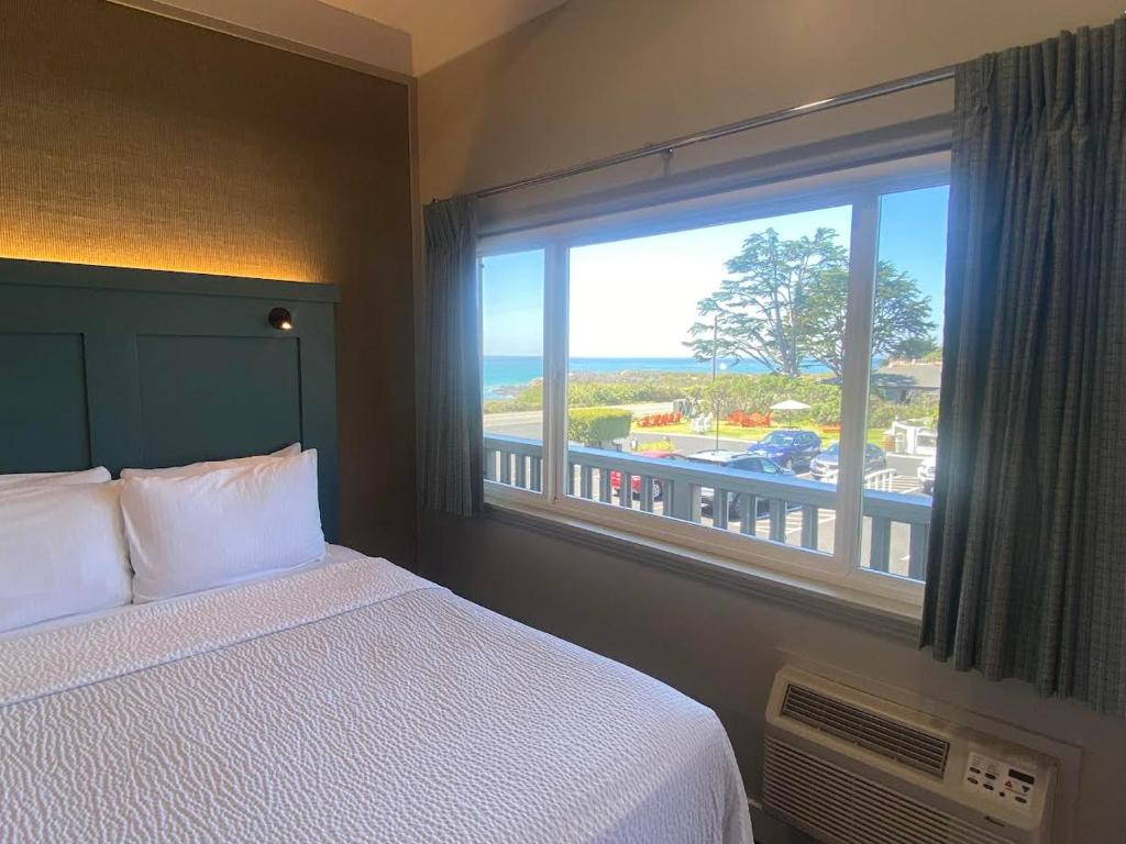 a bedroom with a bed and a large window at Castle Inn in Cambria