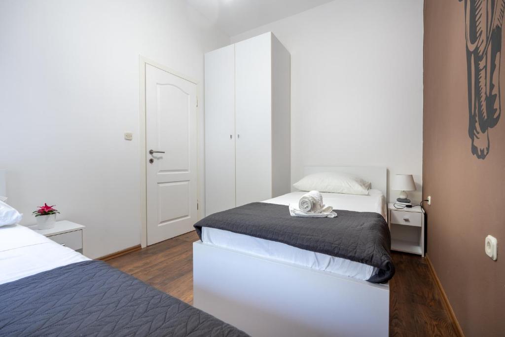 a white bedroom with two beds and a mirror at Ivano in Ston