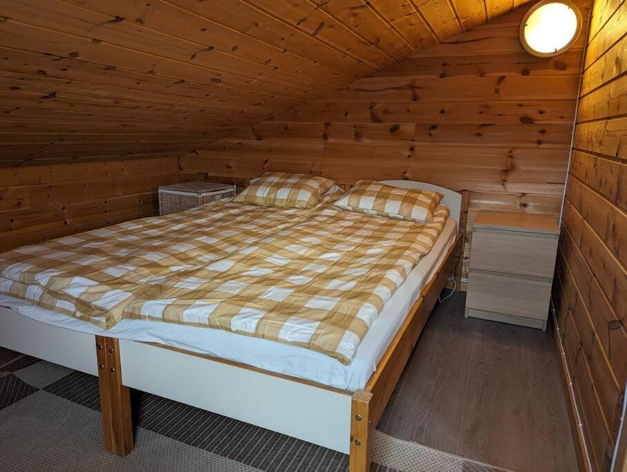 ein Schlafzimmer mit einem Bett in einer Holzhütte in der Unterkunft Hardangerfjord view 2 in Kvam