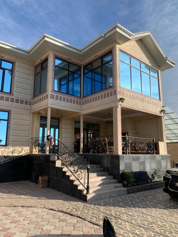 a large house with glass windows and stairs at CHINAR hotel in Kaji-Say