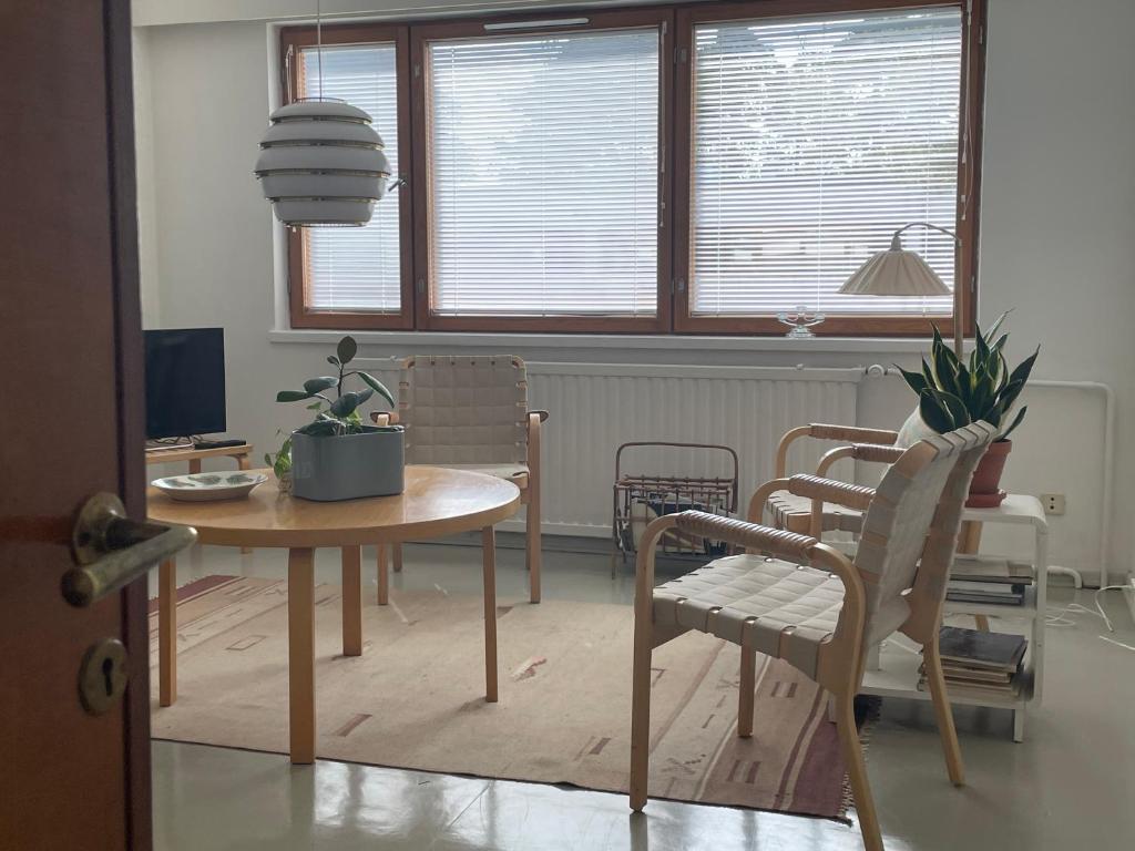 uma mesa de jantar e cadeiras num quarto em Aalto Apartments Sunila Honkala 2 em Kotka