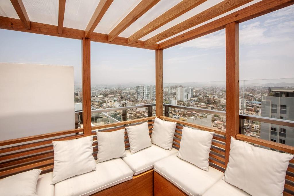 - un balcon avec un canapé blanc et des oreillers dans l'établissement Grau by Wynwood House, à Lima