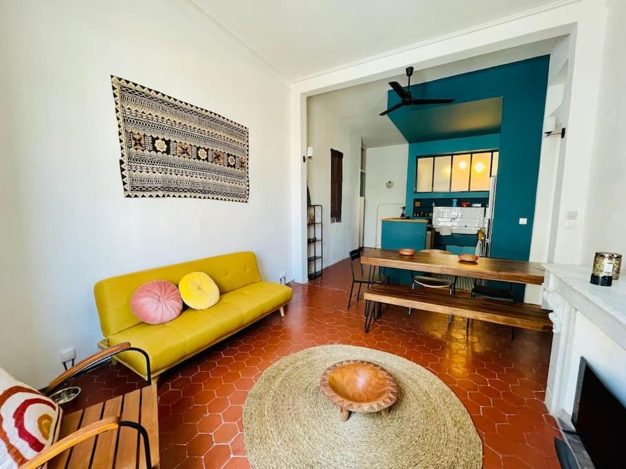 a living room with a yellow couch and a table at LE MONTMORENCY 41 Authentique et Cosy Centre Historique Proximité Parking Gratuit in Sète