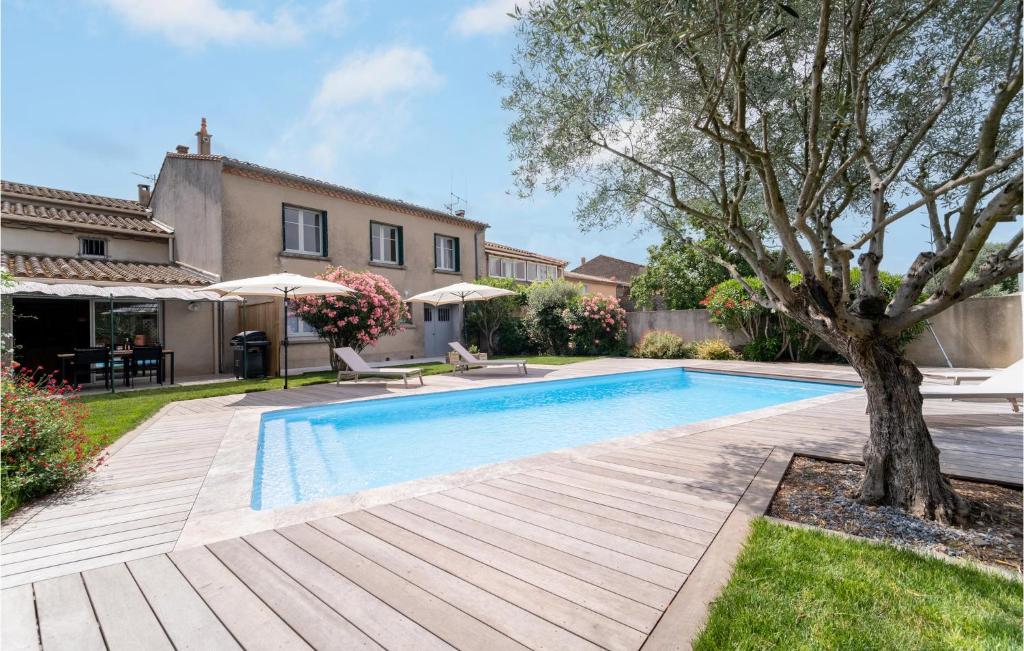 una piscina con un árbol al lado de una casa en Beautiful Home In Villegly With Kitchen, en Villegly