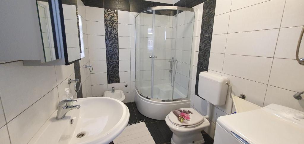 a white bathroom with a sink and a toilet at Guesthouse Palma in Mali Lošinj