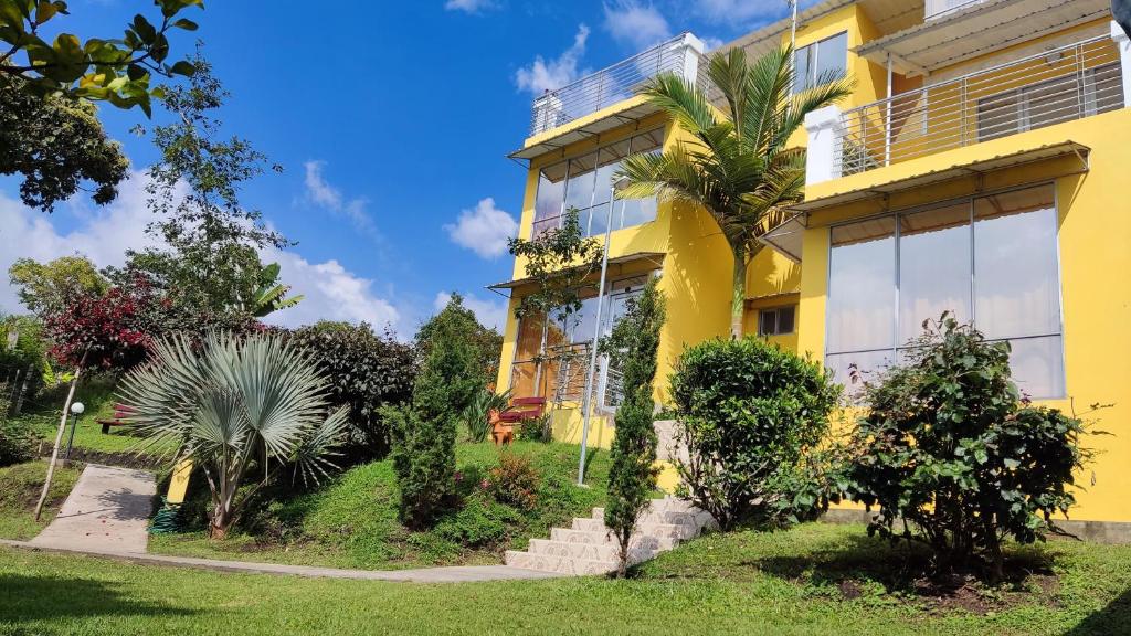 ChachagüíHOTEL PANORAMA SOL的前面有植物的黄色房子