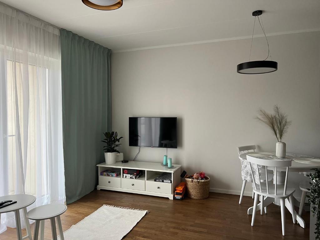 a living room with a tv and a table with chairs at Apartment Kvartsi in Tartu