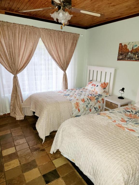 a bedroom with two beds and a window at 5@Stock Accommodation in Bloemfontein