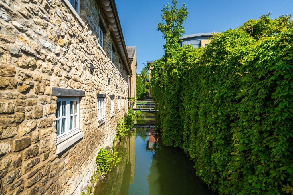a canal between two buildings next to a river at Central waterside in Oxford