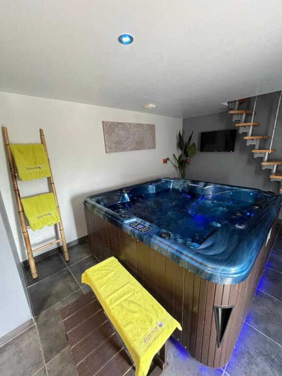 une grande baignoire bleue dans une chambre avec un escalier dans l'établissement Un moment zen à Warhem, à Warhem