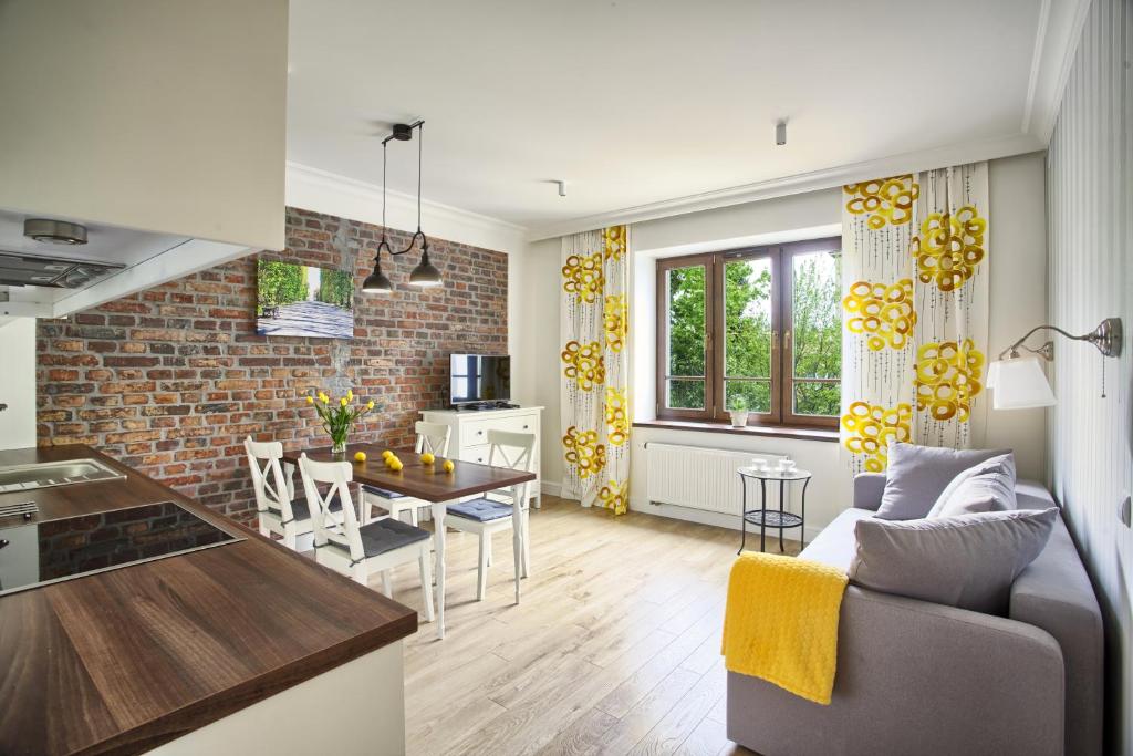 グディニャにあるVilla Allegra Apartments Gdynia Orłowoのレンガの壁のリビングルームとキッチンが備わります。