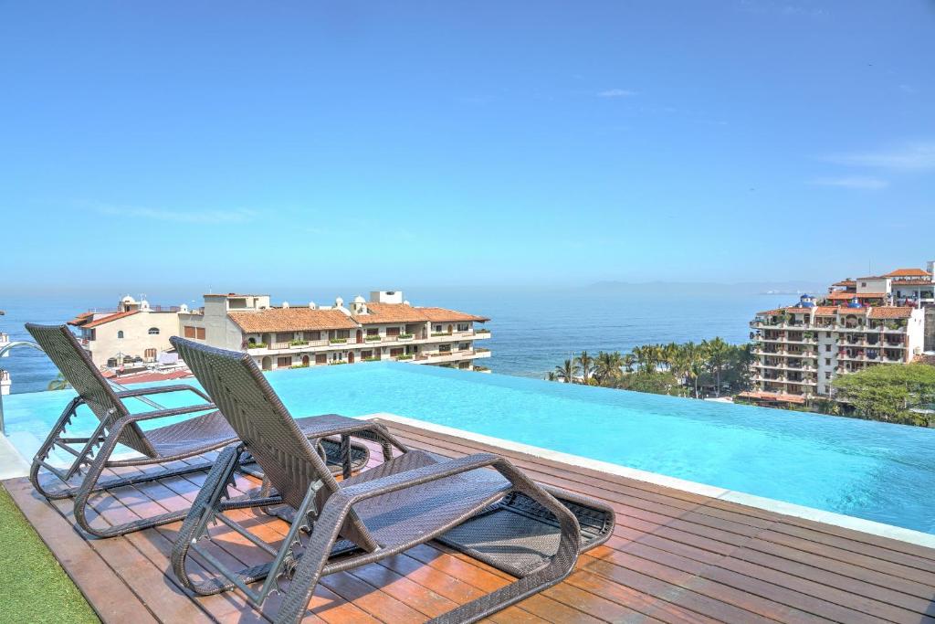 zwei Stühle auf einer Terrasse neben einem Pool in der Unterkunft Nayri Life & Spa 408 in Puerto Vallarta