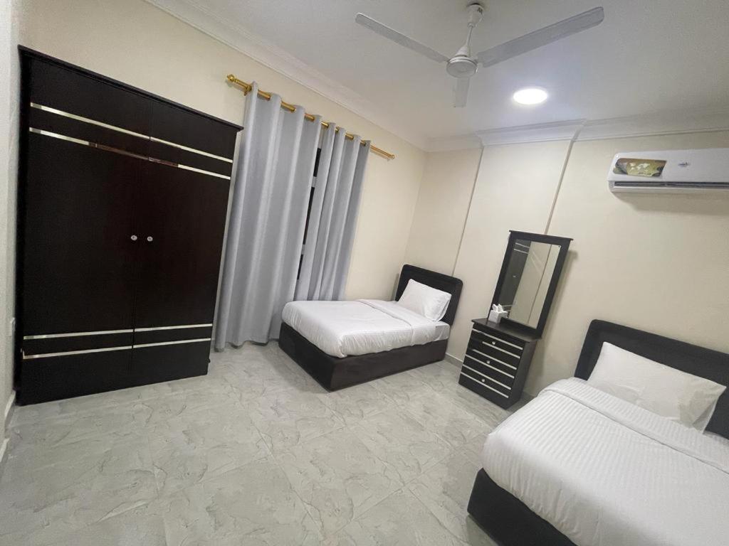 a hotel room with two beds and a mirror at Red-15 - Bn Saif in Salalah