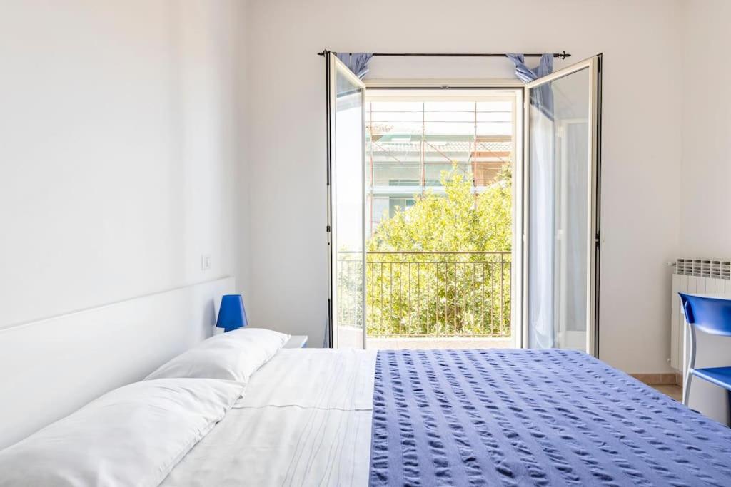 a white bed in a room with a large window at Affittacamere Bellavista in Castiglione di Sicilia