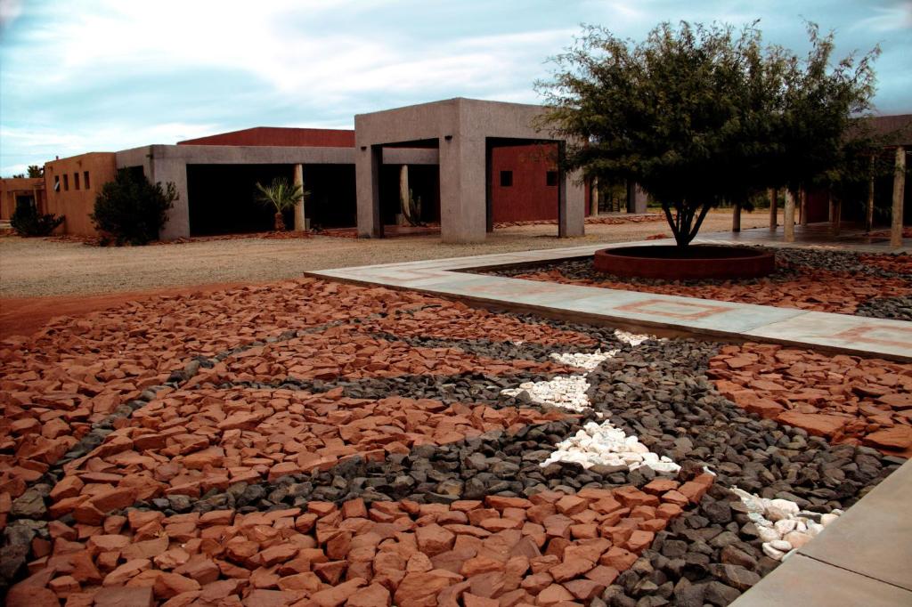 a building with a tree in the middle of a yard at Hotel Boutique Cañon de Talampaya in Villa Unión