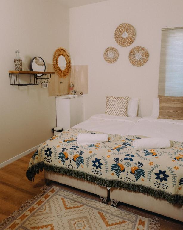 a bedroom with a bed with a floral bedspread on it at Hippie House היפי האוס in Mitzpe Ramon