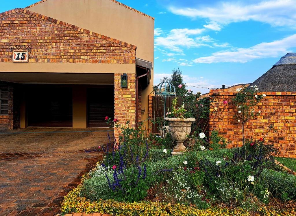 a brick building with a courtyard with a flower garden at Greenhouse in Boksburg