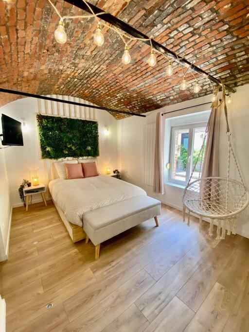 une chambre avec un lit dans une pièce avec un plafond dans l'établissement Les Amourettes, à Rouen