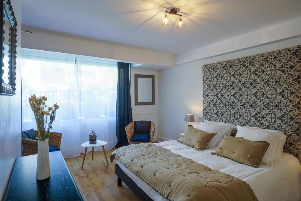 a bedroom with a large bed and a window at Abri du Pêcheur in La Forêt-Fouesnant