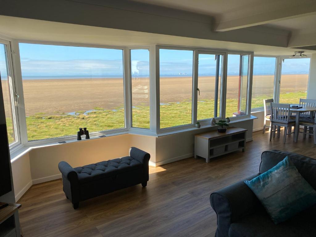 a living room with a couch and large windows at Flat 3, Sandridge Court in Fleetwood