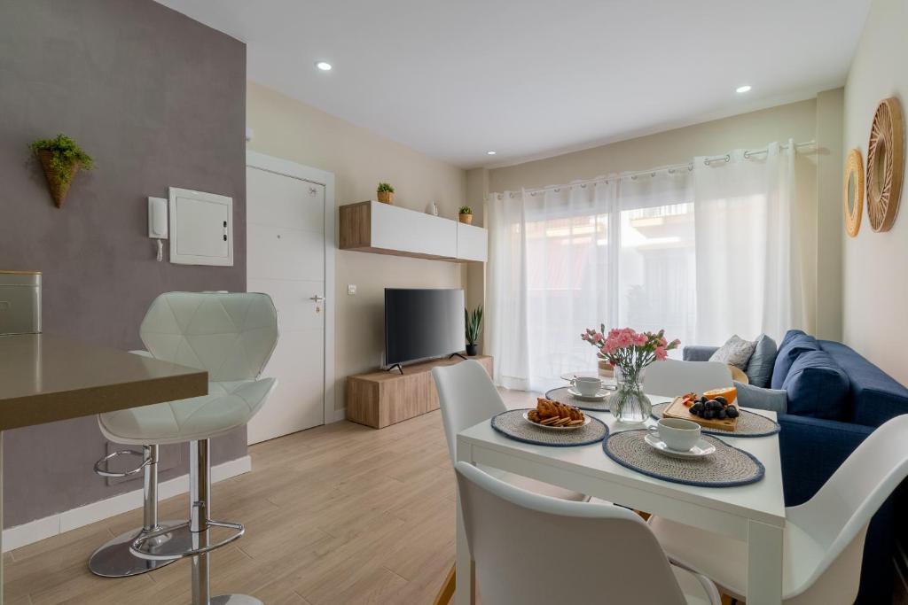 una cucina e un soggiorno con tavolo e sedie di Apartamento Salinas a Fuengirola
