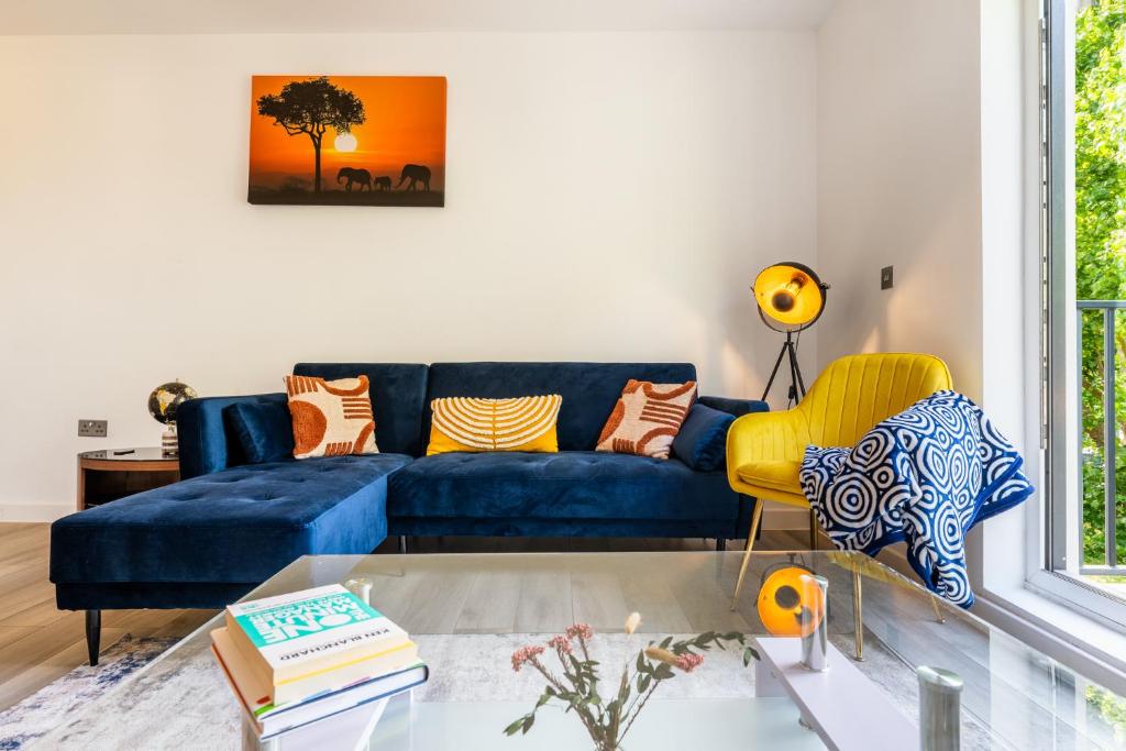 a living room with a blue couch and yellow chairs at Ashview 8 - Heathrow - Business - Free Parking in Staines upon Thames