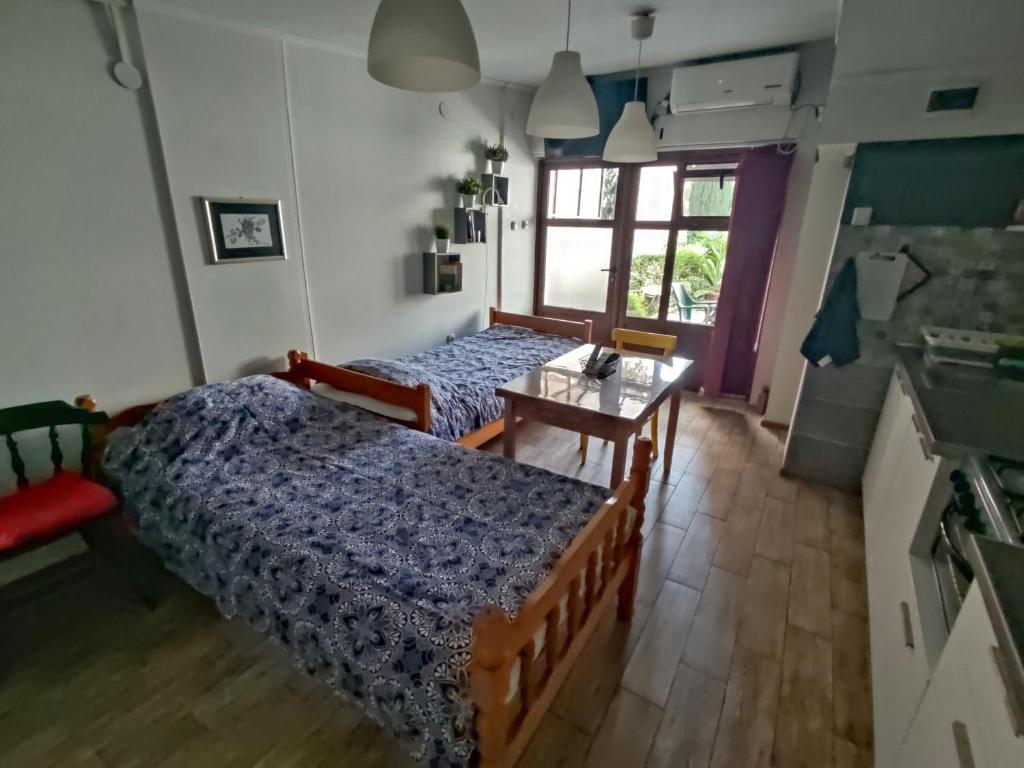 1 dormitorio con 2 camas, mesa y ventana en Studio House - Getaway, en Bitola