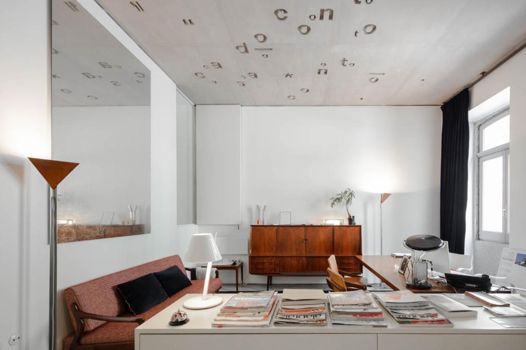 een woonkamer met een tafel met boeken erop bij Casa do Conto - Arts & Residence in Porto