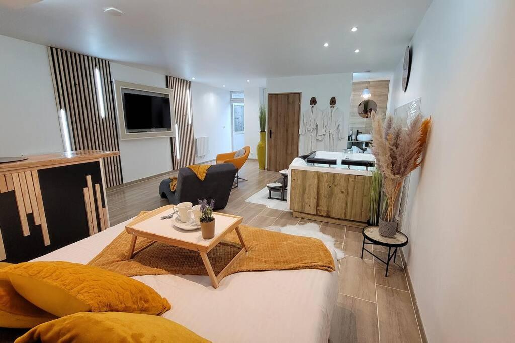 una camera con un letto con un tavolo e un soggiorno di Appartement Privatif confort LA PHINE DETENTE a La Bassée