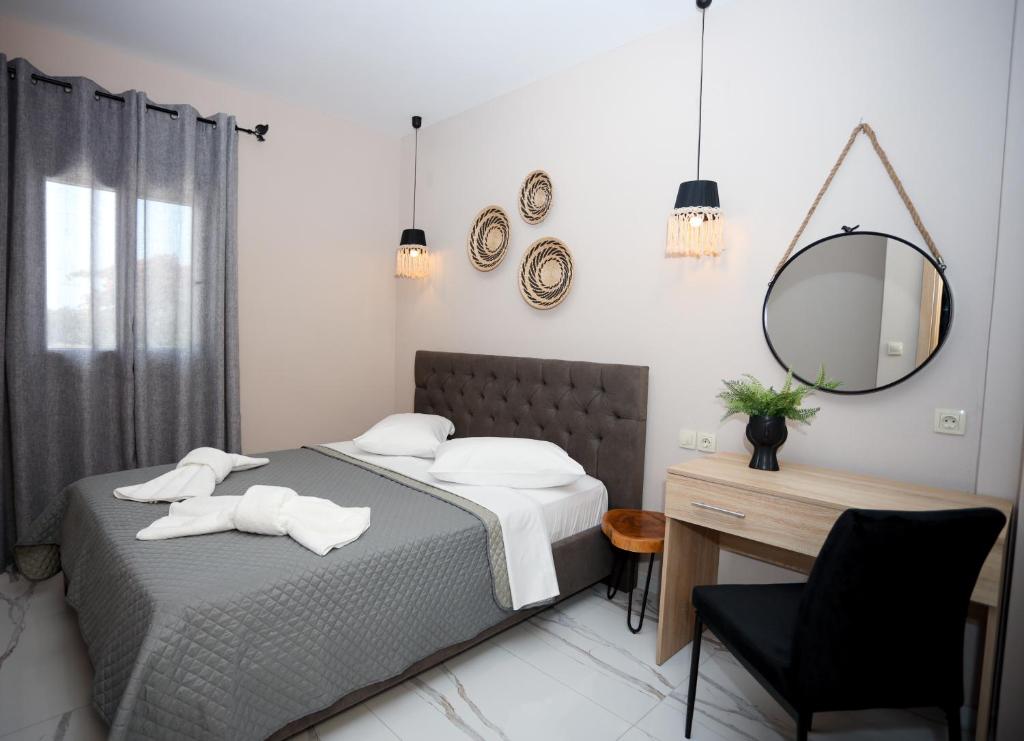 1 dormitorio con cama, escritorio y espejo en GreKa apartments, en Kalivia Poligirou