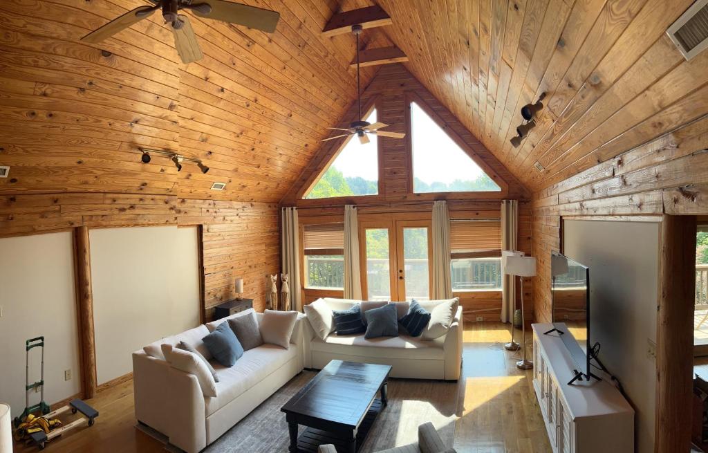ein Wohnzimmer mit einer Gewölbedecke aus Holz in der Unterkunft Lakefront-Private-Huge Log Cabin 