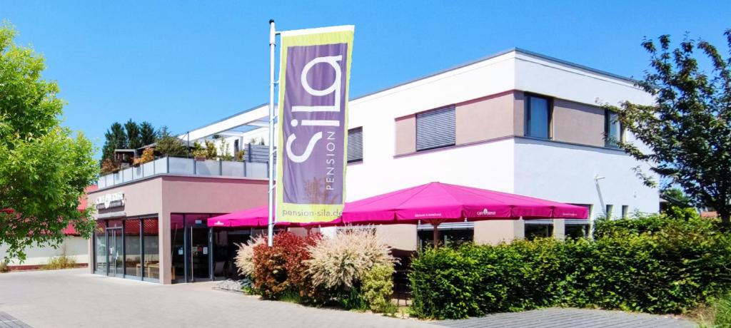 a building with a large sign in front of it at Pension SiLa in Groß-Umstadt