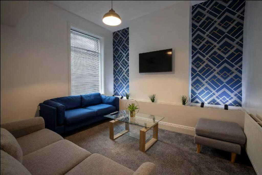 a living room with a blue couch and a table at Abingdon House Workstays UK in Middlesbrough