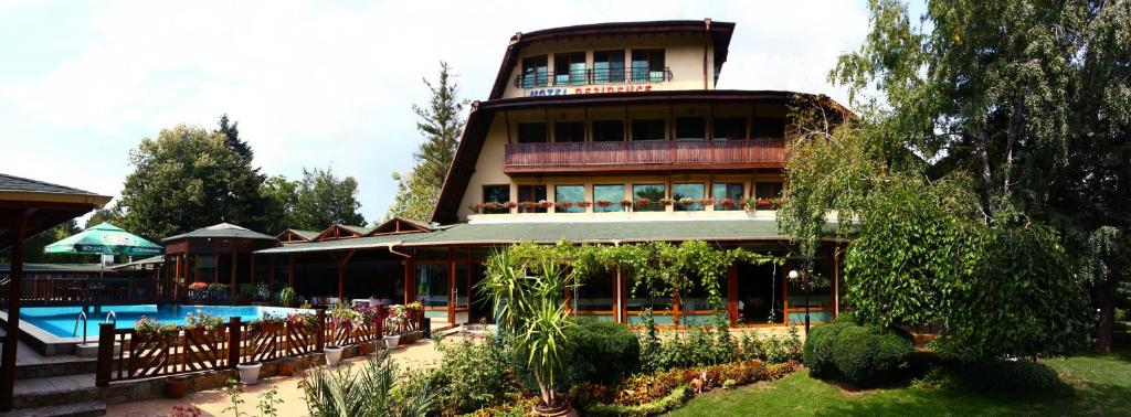 a large building with a swimming pool in front of it at Family Hotel Residence in Dobrich