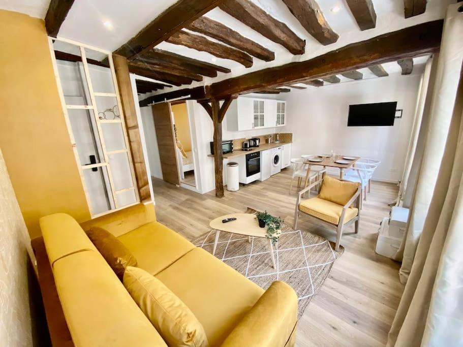 sala de estar con sofá amarillo y mesa en Le Mimosa, en Rouen