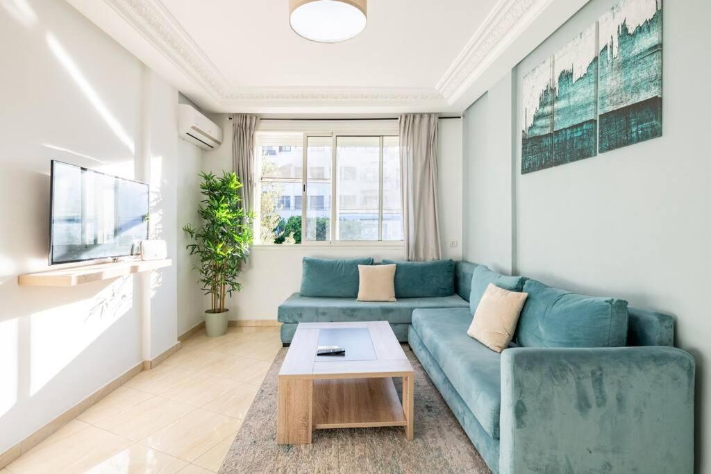 un soggiorno con divano blu e tavolo di TT Holidays Hassan Tower 3Bedrooms a Rabat