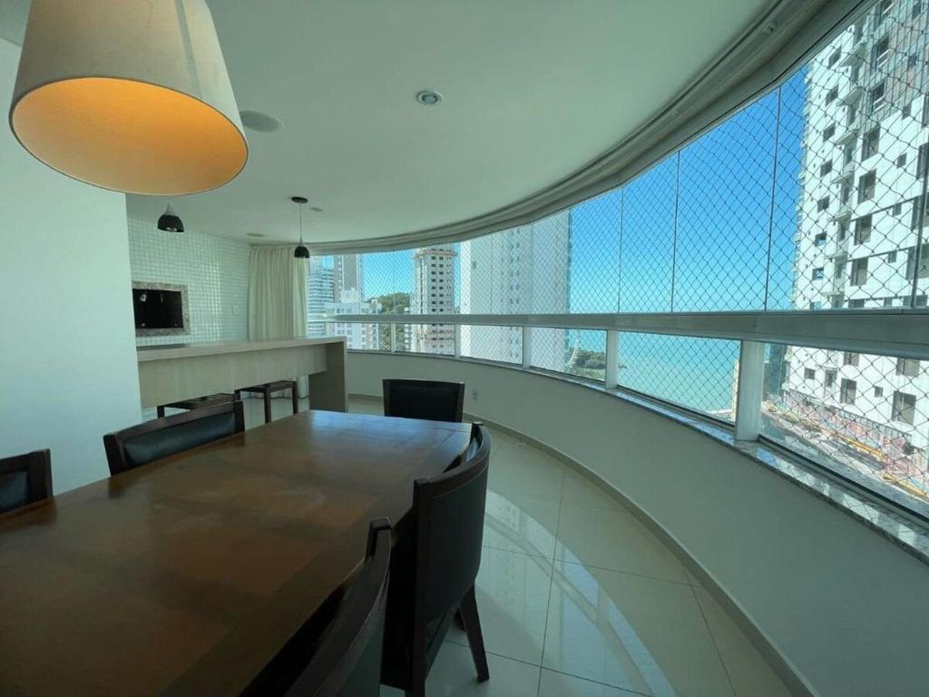 a dining room with a table and chairs and a balcony at Linda Vista, Um apartamento por andar, 3 Suítes, 2 Garagens in Balneário Camboriú