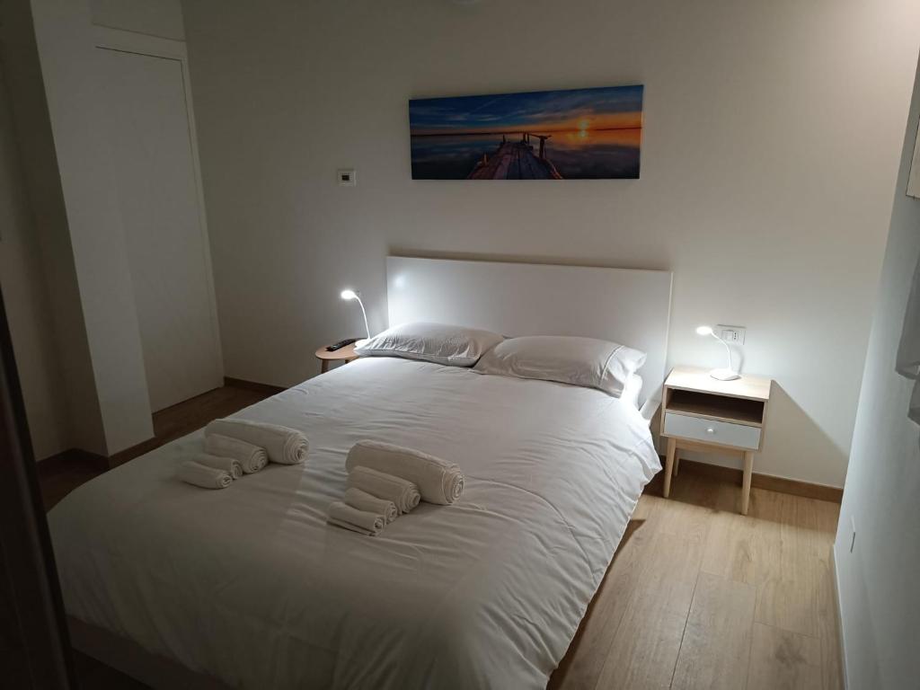 een slaapkamer met een wit bed met 2 kussens erop bij La CASA di LUCA/Fiera e Stazione/Aria condizionata in Bologna