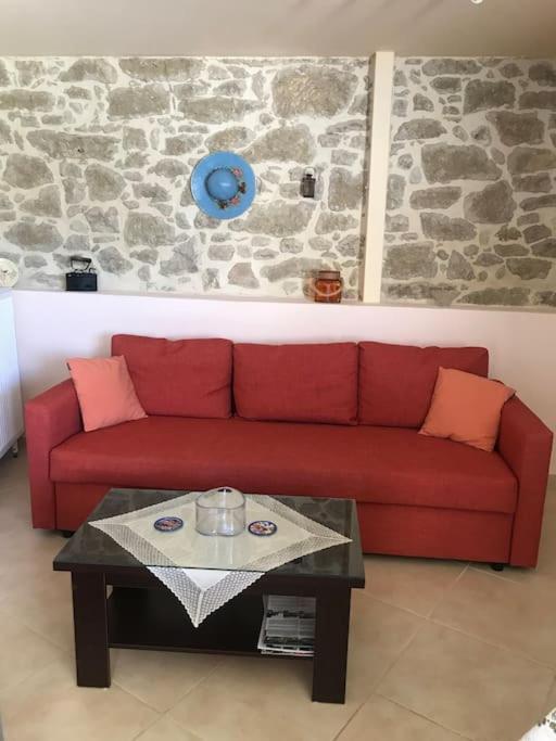 a red couch in a living room with a table at Το σπίτι του Καπετάν-Γιάννη in Panasós