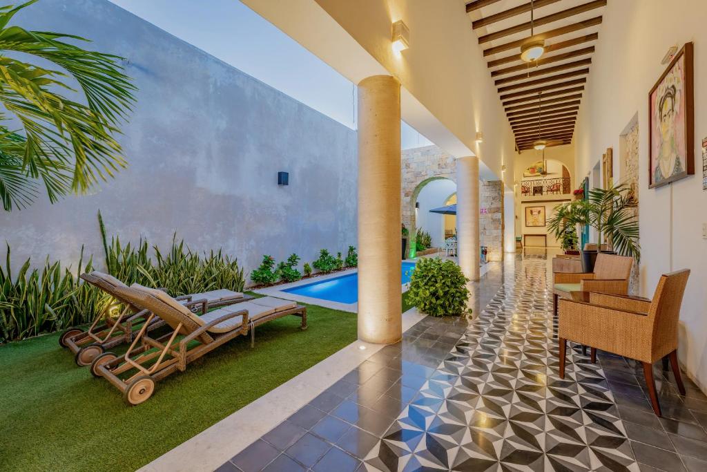 een woonkamer met een zwembad en een huis bij Casona Las Tres Marías - Hotel Only adults in Mérida