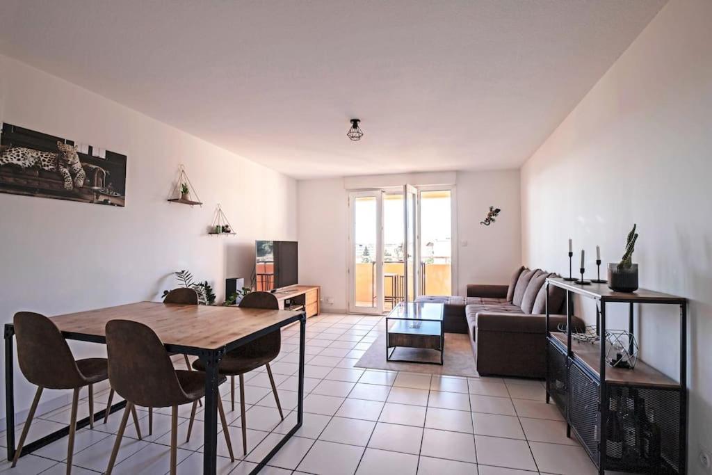 een woonkamer met een tafel en een bank bij *Appt Rue Tour Gayraud, 4 Pers, Parking, Wi-Fi* in Montpellier
