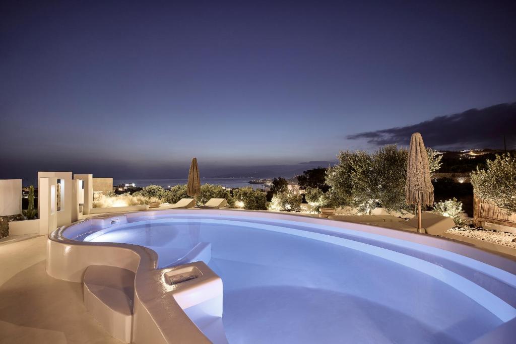 a large swimming pool with a view of the ocean at Sharm Hotel Mykonos in Mýkonos City