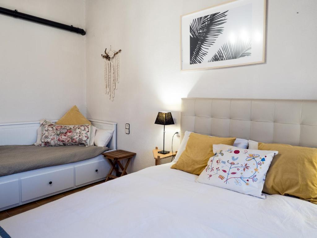 1 dormitorio con cama blanca y cabecero blanco en Acogedor apartamento entre montañas, en Sant Corneli de Cercs 