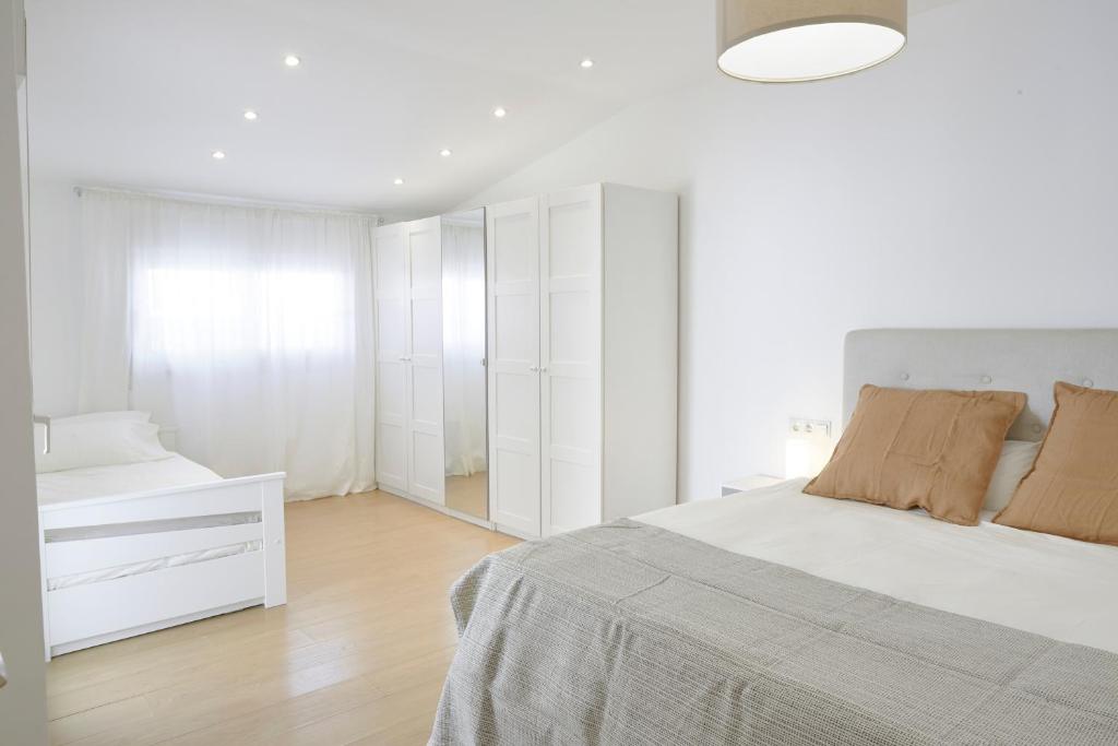 a white bedroom with a bed and a white dresser at City Center Penthouse with Solarium 2 minutes from the Beach in Fuengirola